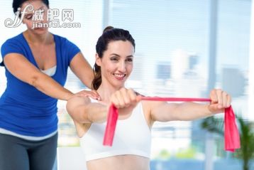 40到44歲,白人,30歲到34歲,室內,白晝_gic12763359_Brunette stretching with her coach and pink cloth in exercise room_創意圖片_Getty Images China